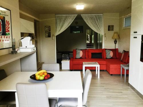 a living room with a table and a red couch at Casa di Sissy con Piscina Privata - Zona Villa Igea in Acqui Terme
