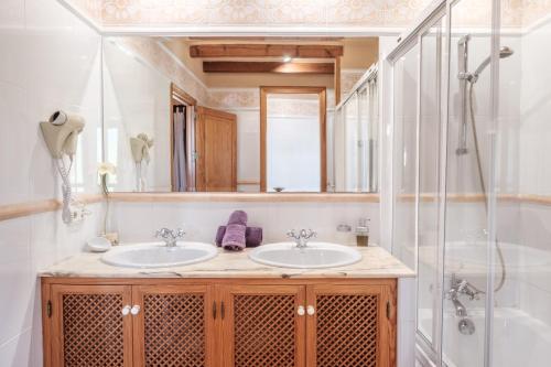 a bathroom with two sinks and a shower at Villa Ses Marjades in Cala Vadella