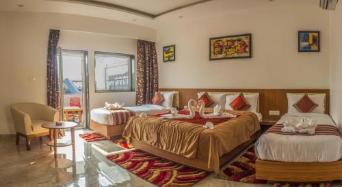 una habitación de hotel con 2 camas en una habitación en Hotel Suktara International en Siliguri