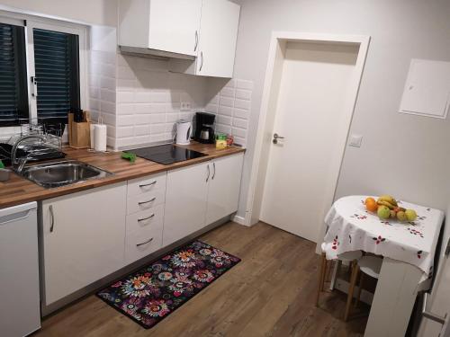 a kitchen with white cabinets and a table with fruit on it at Madeira Inn Casa da Paz in Calheta