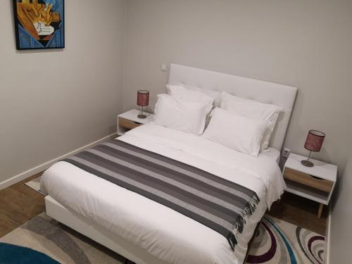 a bedroom with a large white bed with two night stands at Madeira Inn Casa da Paz in Calheta