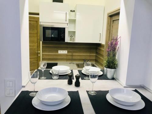 een eettafel met borden en wijnglazen erop bij Heart Apartment with FREE Private Parking in Boedapest