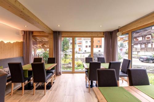 Apparthotel Marteshof في بفيلديرز: قاعة اجتماعات مع طاولات وكراسي ونوافذ كبيرة