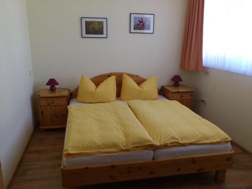 1 dormitorio con 1 cama con sábanas y almohadas amarillas en Eifel - Pension en Kall