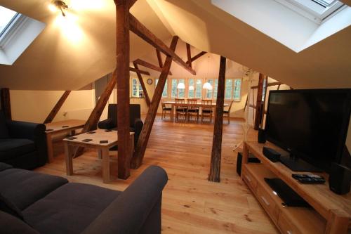a living room with a flat screen tv and a couch at Ferienwohnungen Felsenkeller Bielatal in Bielatal