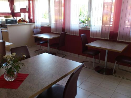 a restaurant with tables and chairs and windows at Eifel - Pension in Kall