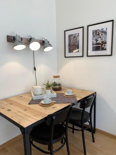 a dining room table with black chairs and a wooden table at Sandra's Lounge in Klagenfurt