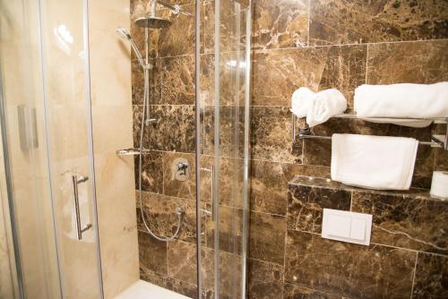 a shower with a glass door in a bathroom at ART Hotel in Sibiu