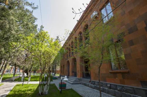 a brick building with trees in front of it at AnnaBella Boutique Hotel in Yerevan