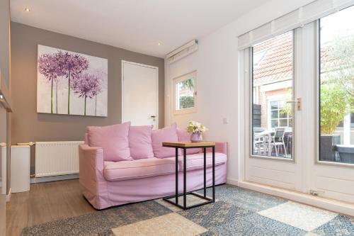 a living room with a pink couch and a table at B&B Bike Studio Amsterdam in Amsterdam