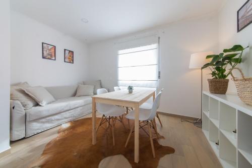 a white living room with a table and a couch at Casas Do Mar in Ribamar