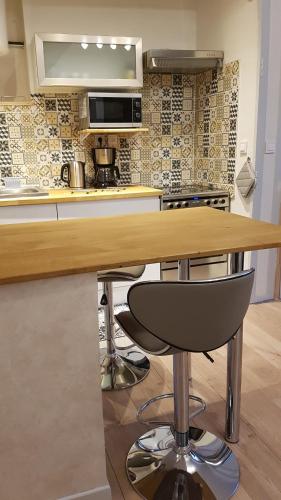a kitchen with a wooden counter with a bar stool at A la liberté in Salins-les-Bains