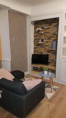 a living room with a couch and a table at A la liberté in Salins-les-Bains