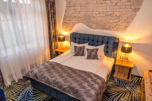 a bedroom with a large bed with two pillows at ART Hotel in Sibiu