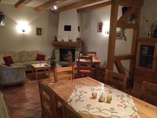 una sala de estar con una mesa y un sofá en Landhaus Gohrisch, en Kurort Gohrisch
