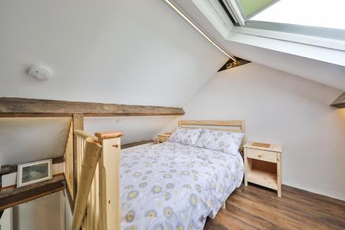 a attic bedroom with a bed and a window at Black Mountains Barn in Abergavenny
