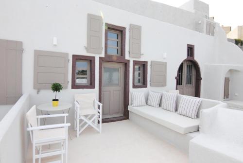 a living room with white furniture and a table at White Grape Suites in Oia