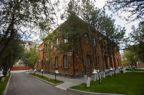 a large brick building with trees in front of it at AnnaBella Boutique Hotel in Yerevan