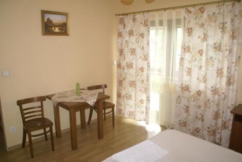 une chambre avec une table, des chaises et une fenêtre dans l'établissement Hotel Prokocim, à Cracovie