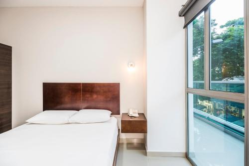 a bedroom with a bed and a large window at Ribai Hotels Santa Marta in Santa Marta