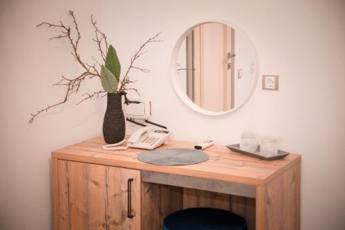 a bathroom with a vanity with a mirror and a phone at ART Hotel in Sibiu