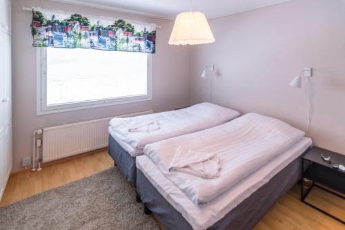 2 camas en una habitación con ventana en Jääskän Loma Ratatie 3 asunto 6 Kauhava en Kauhava