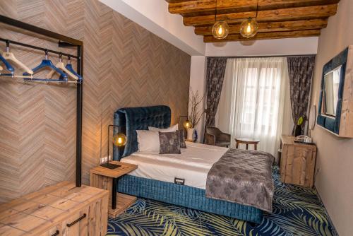 a bedroom with a bed with a blue bed frame at ART Hotel in Sibiu