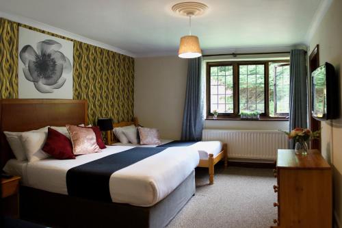 a hotel room with two beds and a window at Little Foxes Hotel & Gatwick Airport Parking in Crawley