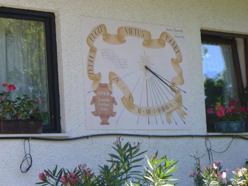 a clock on the side of a building with plants at Albergo Negritella in Borgo