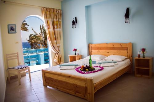 فندق البريمو دهب في دهب: غرفة نوم بها سرير مع وعاء من الفواكه عليها