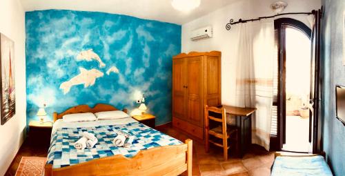 a bedroom with a bed and a blue wall at Arena Bianca in La Caletta
