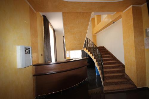 a stairway in a building with a wooden staircase at Hotel Eden in Şimian