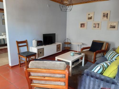 a living room with a couch and a tv at Alojamento Local de Santa Catarina in Praia da Vitória