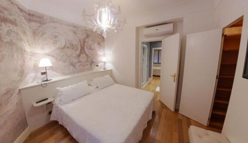 a bedroom with a white bed and a chandelier at Hotel Miramare & Spa in Sestri Levante