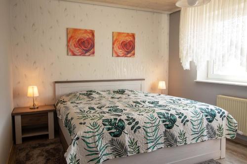 FrankenauにあるFerienwohnung Am-Brueckenrainのベッドルーム1室(ベッド1台付)が備わります。壁には絵画2点が飾られています。