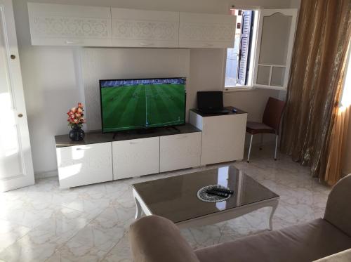 a living room with a flat screen tv on a white cabinet at Dar Ezzahra in Tozeur