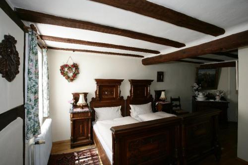 a bedroom with a wooden bed with white sheets at Hotel zum Riesen - älteste Fürstenherberge Deutschlands in Miltenberg