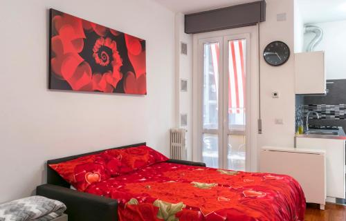 Un dormitorio con una cama roja en una habitación. en Bright House in Milan, en Milán
