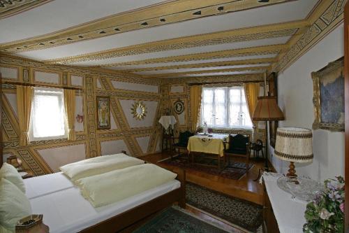 Un dormitorio con una cama y una mesa. en Hotel zum Riesen - älteste Fürstenherberge Deutschlands, en Miltenberg