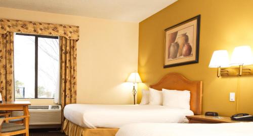 um quarto de hotel com duas camas e uma janela em Tombstone Grand Hotel, a Baymont by Wyndham em Tombstone