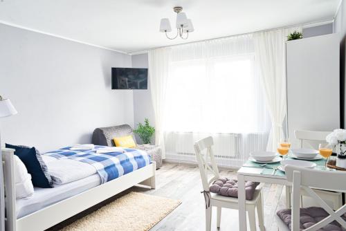 Dormitorio pequeño con cama y mesa en Morning Star Apartments, en Międzyzdroje
