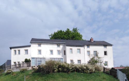 a white house on top of a hill at Landpension Haupt in Sebnitz
