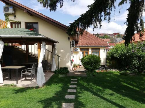 a backyard with a table and a gazebo at Gyöngyszem Vendégház in Eger