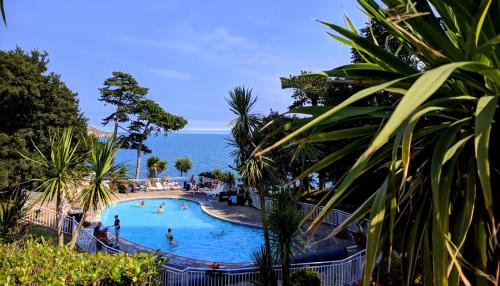 a large swimming pool with the ocean in the background at The Osborne Apartments in Torquay