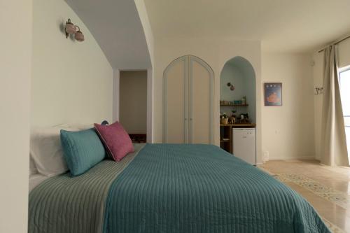 a bedroom with a bed with colorful pillows on it at The Way Inn - Boutique Suites in Safed