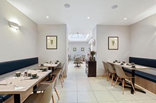 una sala da pranzo con lunghi tavoli e sedie di The Judd Hotel a Londra