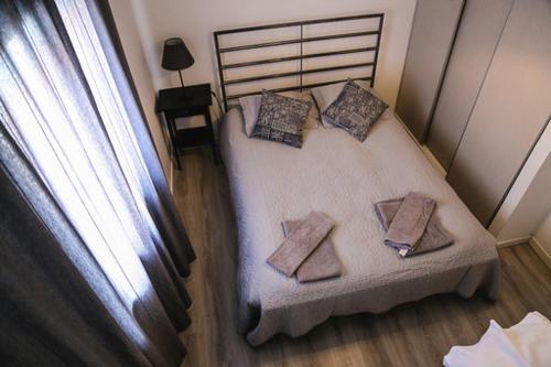a small bedroom with a bed with two pillows on it at Casa Grainha Vidigueira in Vidigueira