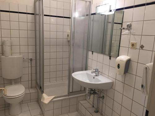 een badkamer met een toilet, een wastafel en een douche bij AltDüsseldorf in Düsseldorf