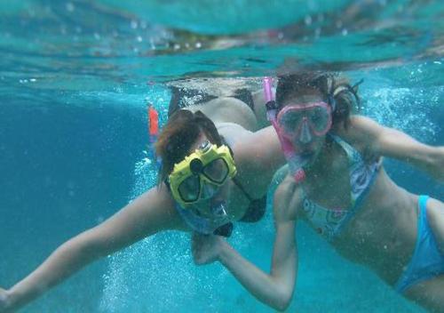 two girls in the water with goggles on at Shaka Caye All inclusive Resort in Belize City