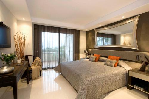 a bedroom with a large bed and a mirror at Apt 102 Guadalmansa Playa, Heaven Beach Apartments in Estepona